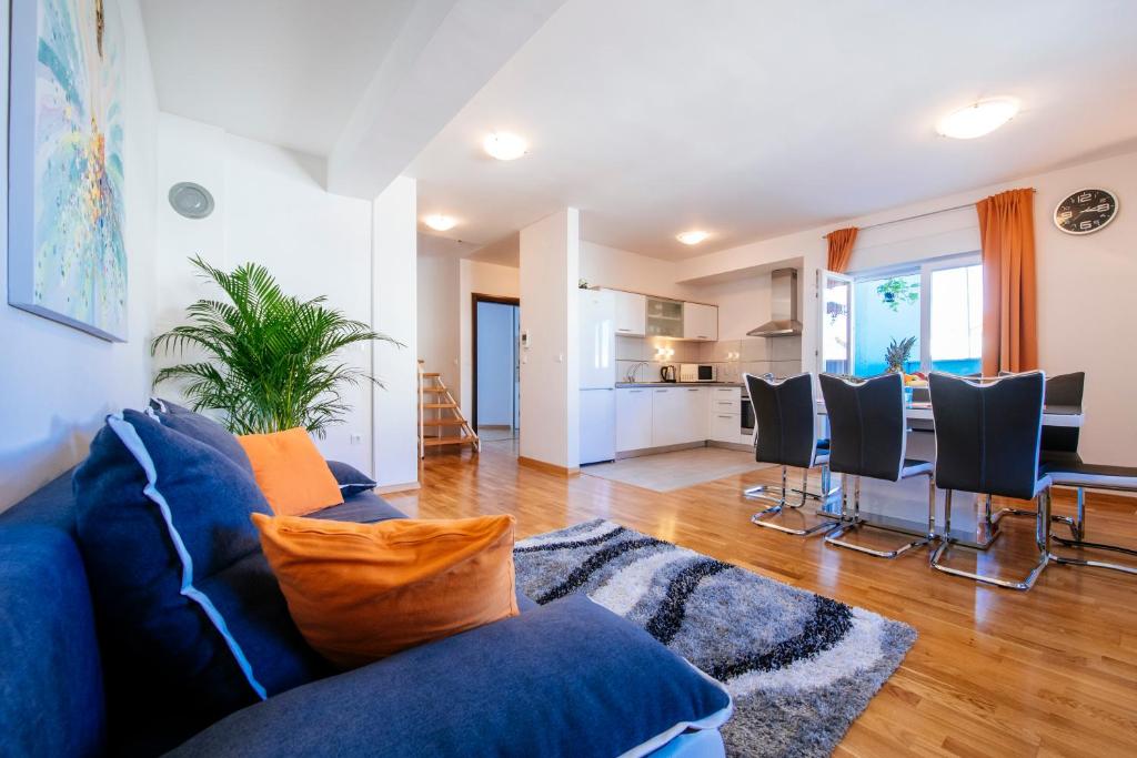a living room with a blue couch and a kitchen at Rainbow apartments in Zadar