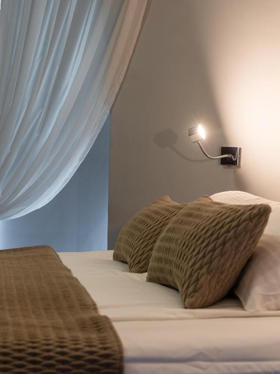 Bed close-up with textured pillows, quilted throw, sheer canopy and adjustable reading lamp.