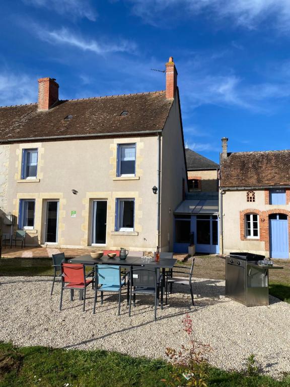 a house with a table and chairs in front of it at La Parenthèse Sancerroise in Savigny-en-Sancerre