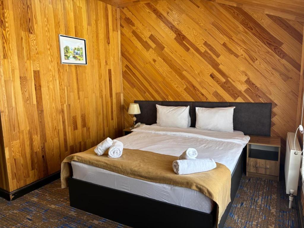 a bedroom with a bed with two towels on it at Şəki Yaylası Hotel in Sheki