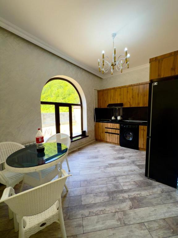 a kitchen with a table and chairs and a window at Qax home in Qax