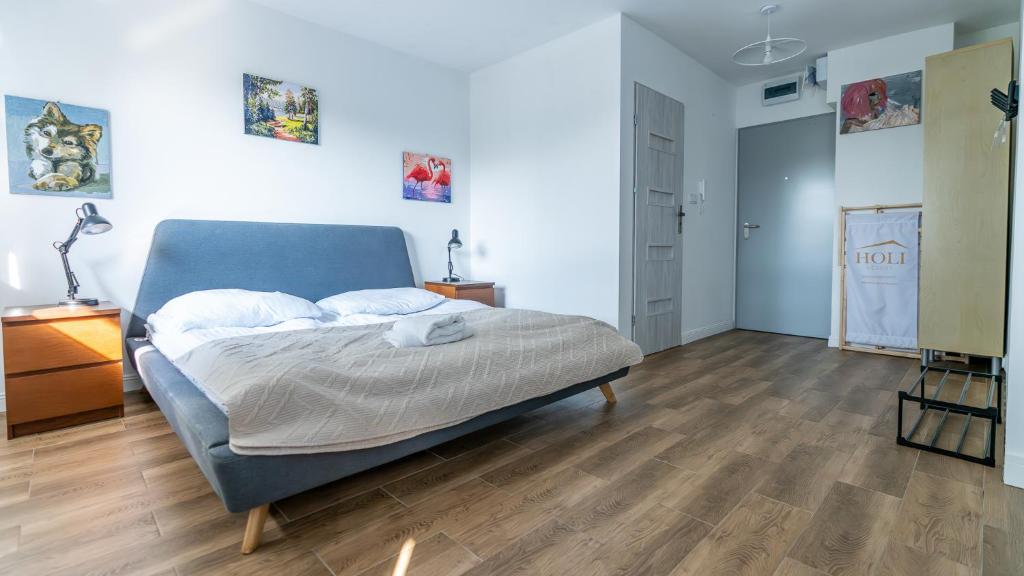 a bedroom with a blue bed and a wooden floor at Wellocum in Serock