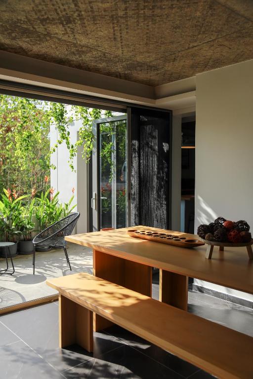 a wooden table in a room with a large window at Ozonizia Family Suites Mai Khao Phuket Yacht Haven in Phuket