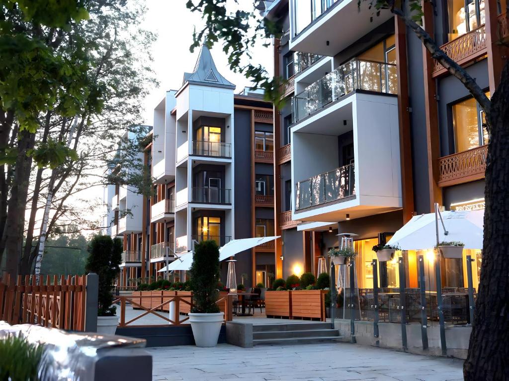 a tall building with tables and umbrellas in front of it at SkyGarden Studio - Private Terrace and View in Quiet Jūrmala in Jūrmala