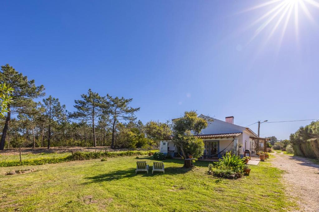 a house with two chairs in a yard at Quintinha Mojud in Rogil