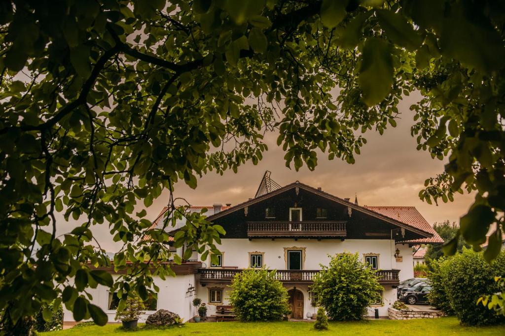 a large white house with a black roof at ALPENHOF Westerbuchberg in Übersee