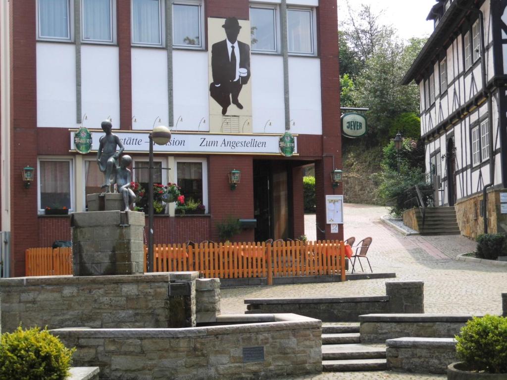 een gebouw met een standbeeld ervoor bij Pension Zum Angestellten in Porta Westfalica