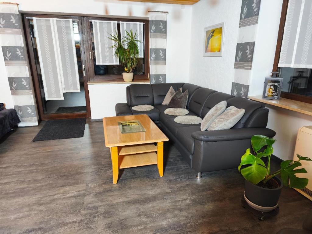 a living room with a black couch and a table at Ferienwohnung Seidl in Waffenbrunn