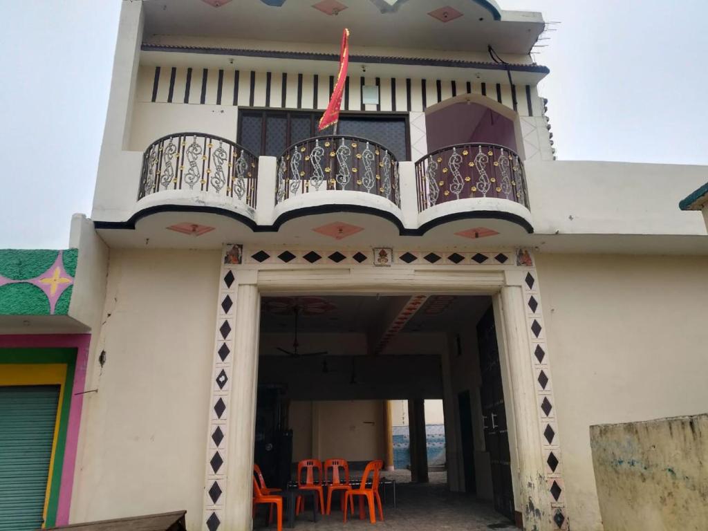 a building with orange chairs and a balcony at Naveen Homestay in Amroha