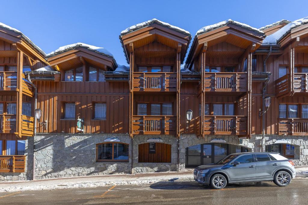 a car parked in front of a building at Résidence Les Chalets du Forum - Courchevel 1850 in Courchevel