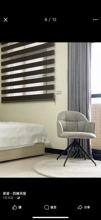 a bedroom with a white chair in front of a window at Siwei B&B in Hou-k'u-t'an