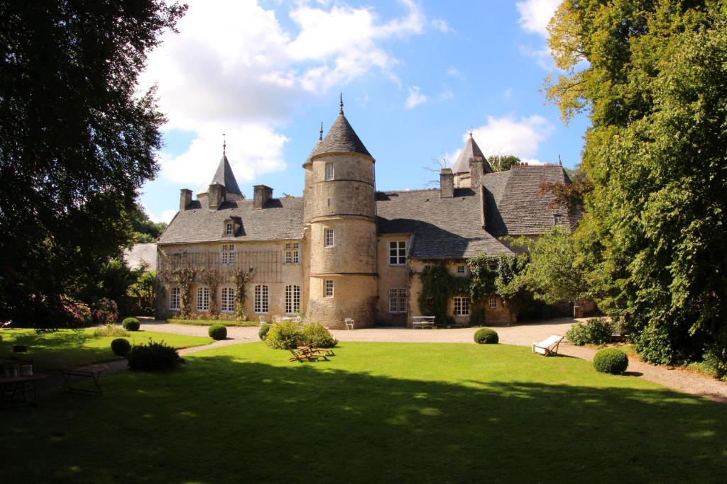 an old castle with a green lawn at Chateau de Flottemanville in Flottemanville