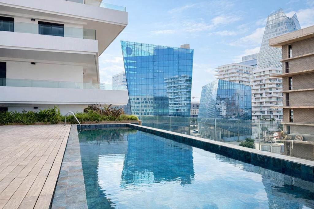 a swimming pool on the roof of a building with tall buildings at Appartement Uptown CFC - Piscine - Gym - Parking Gratuit in Casablanca
