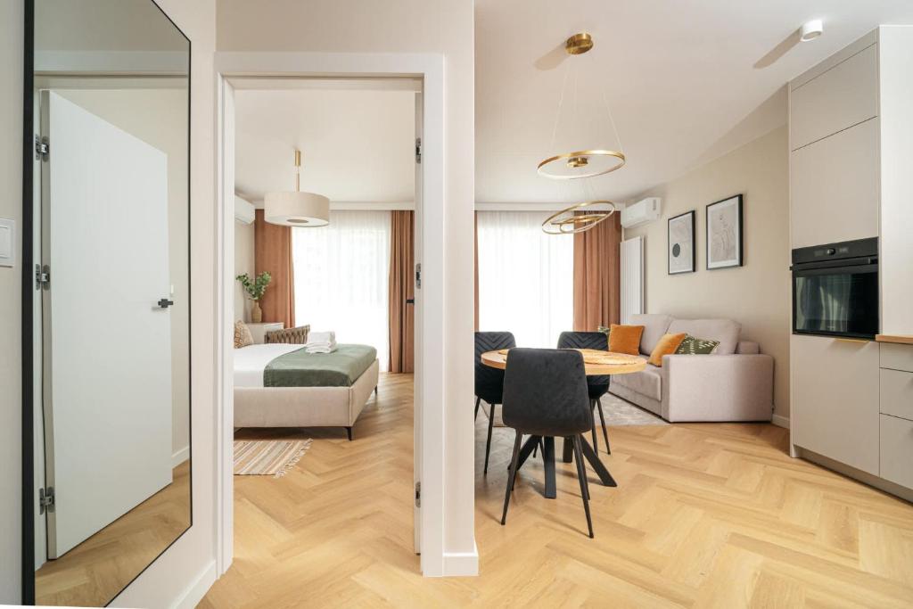 a living room with a dining room table and a bedroom at Sand Boho Harmony Luxury - AC Parking & Balcony - by UniqueRent in Wrocław