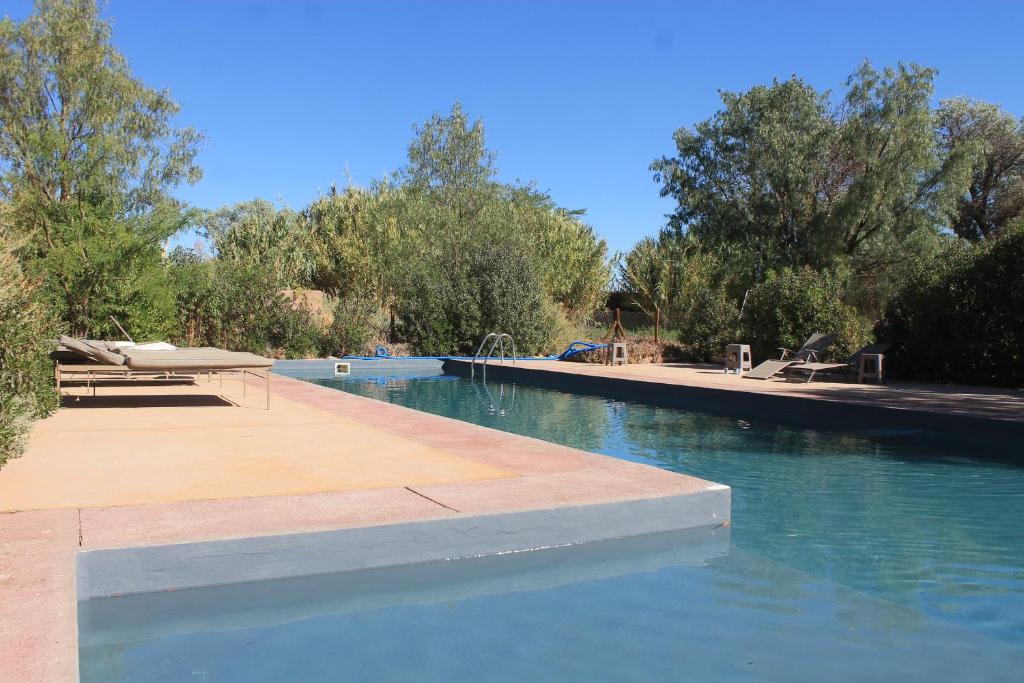a swimming pool with a picnic table and water at Casa Luna in San Pedro de Atacama