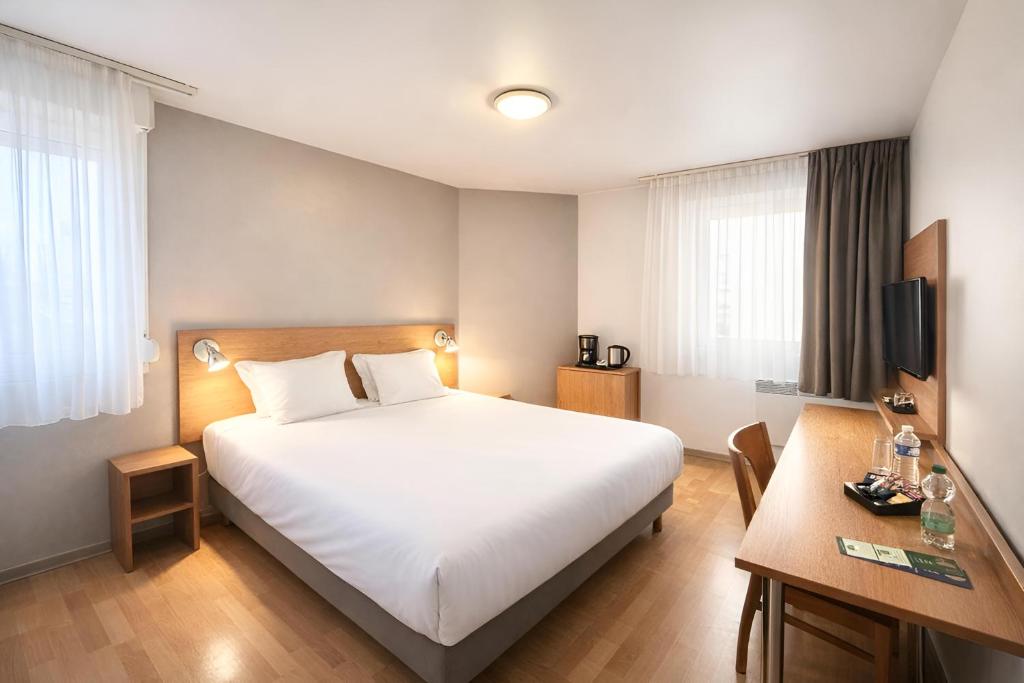 a hotel room with a bed and a desk at Séjours & Affaires Bordeaux de L'Yser in Bordeaux