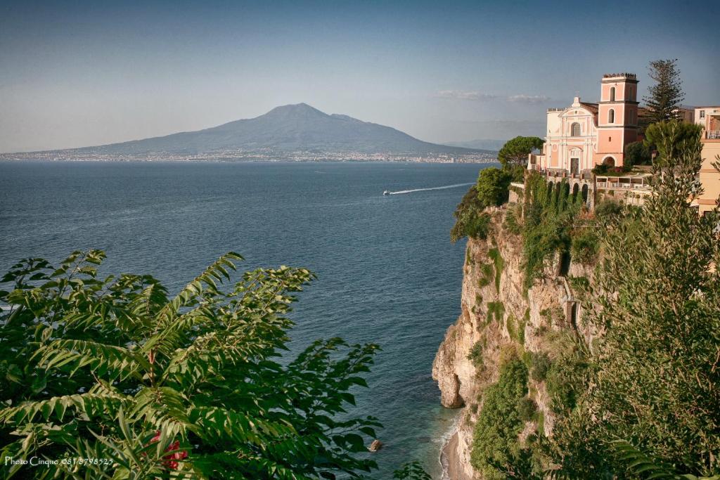 a building on a cliff next to the ocean at VicoStay di Casa Stella in Vico Equense