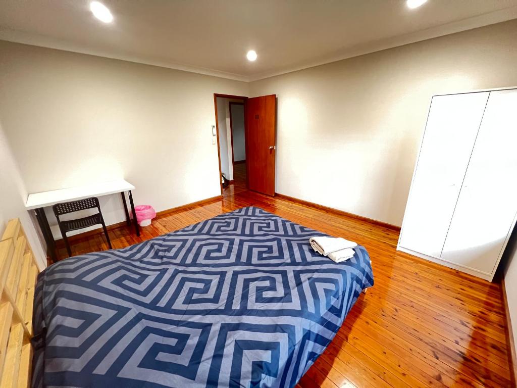 a bedroom with a bed and a desk in it at Room 00 in Baulkham Hills