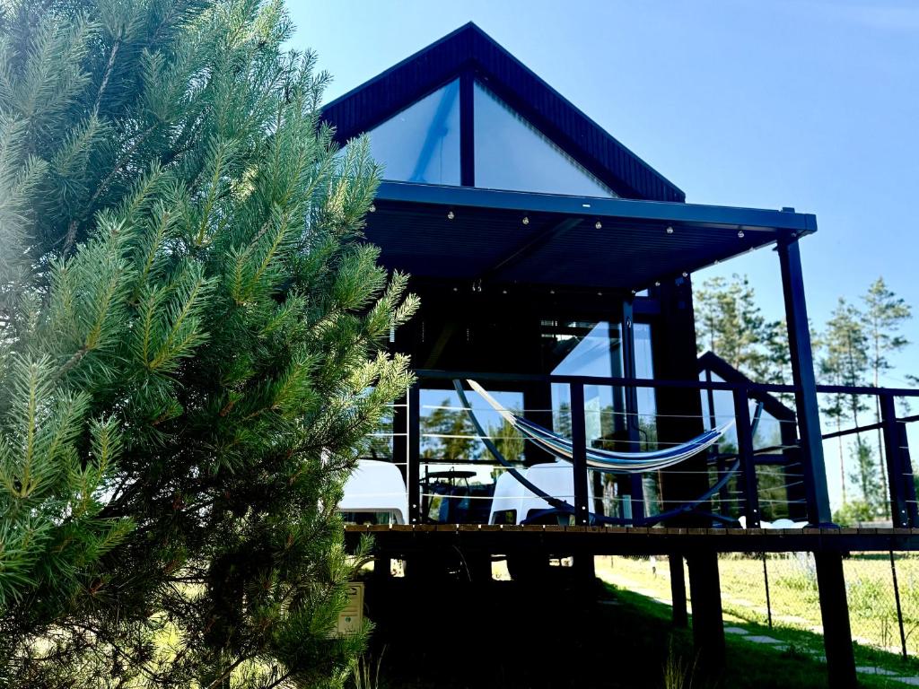 a pavilion with chairs and a tree at Wczasowy Loft Sominy in Sominy