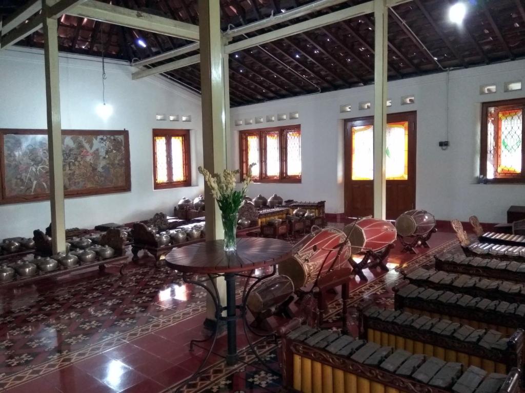an empty room with chairs and tables in a building at Omah Pitoe Yogya Homestay in Yogyakarta