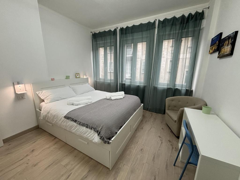 a white bedroom with a bed and a window at Arcobaleno in Turin