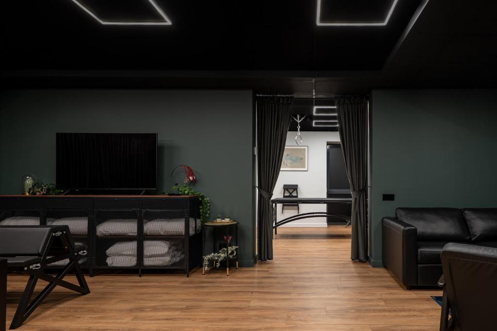 a living room with a couch and a television at BDSM Play Apartments in Vilnius