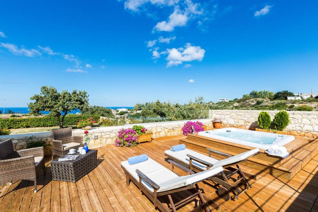 a deck with chairs and a swimming pool at Villa Victoria - A Private Family Gem in Gállos