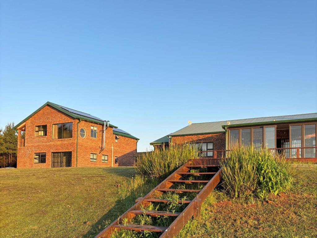 a brick building with some plants in a yard at Shiloh Lodges Tweefontein in Mooiriver