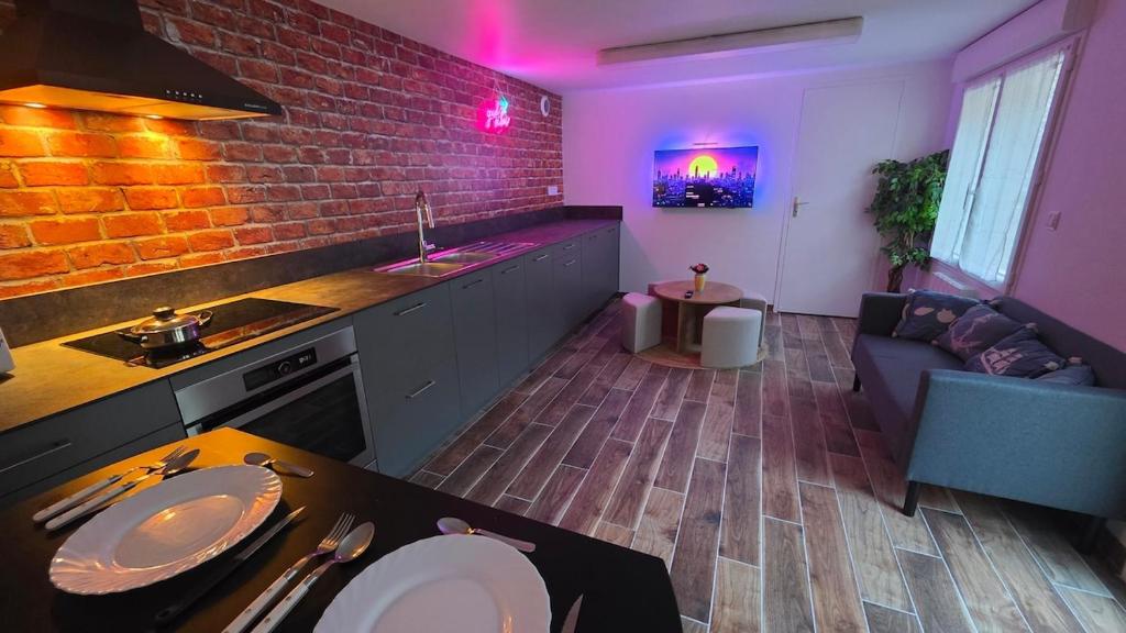 a kitchen and living room with a brick wall at Le Good Vibes in Dieppe