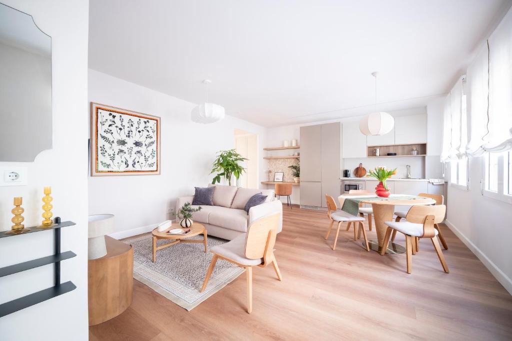 a living room and dining room with a couch and a table at Genesis-Loft Madrid in Madrid