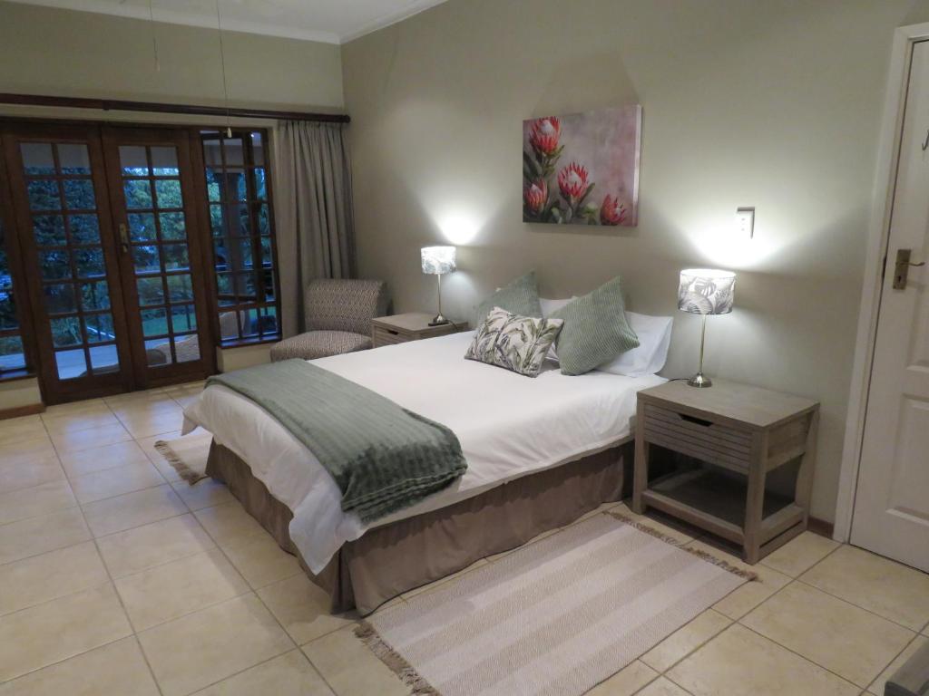 a bedroom with a bed and a table with a lamp at Home on Haven Hill in Durban