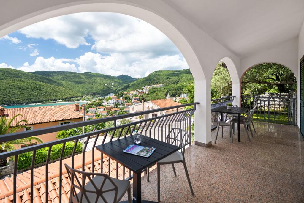 a balcony with tables and chairs and a view at Apartment Zulijani A6 in Rabac