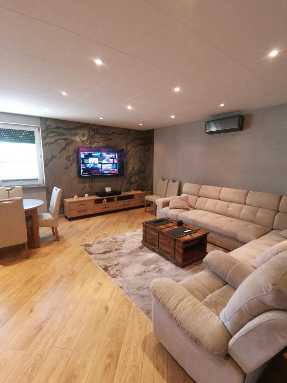 a living room with a couch and a tv at Centro Residence in Kluczbork