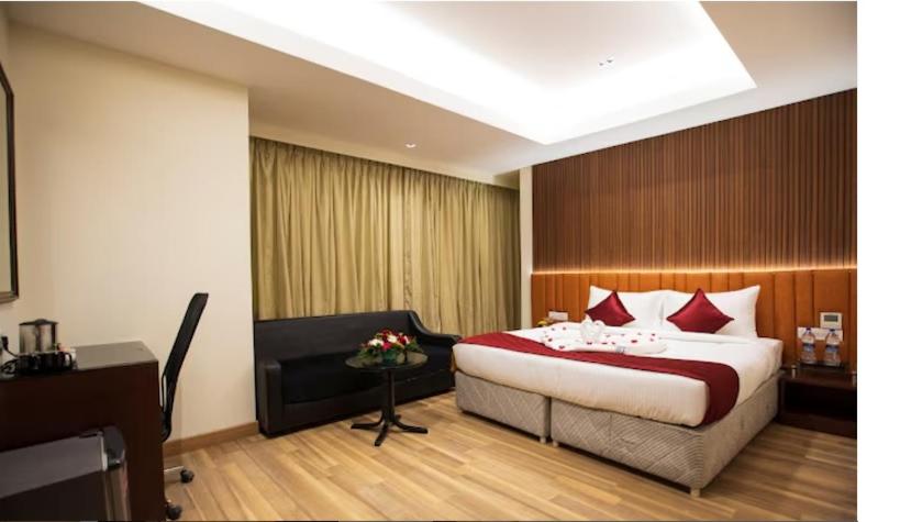 a hotel room with a bed and a desk at Esthell Hotel in Chennai