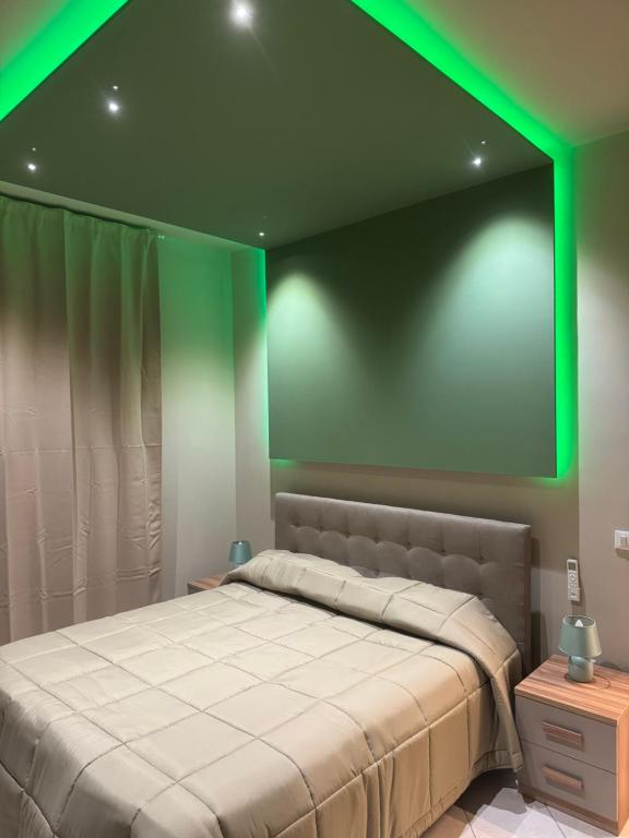 a bedroom with a large bed with a green light at Angel house airport in CTA