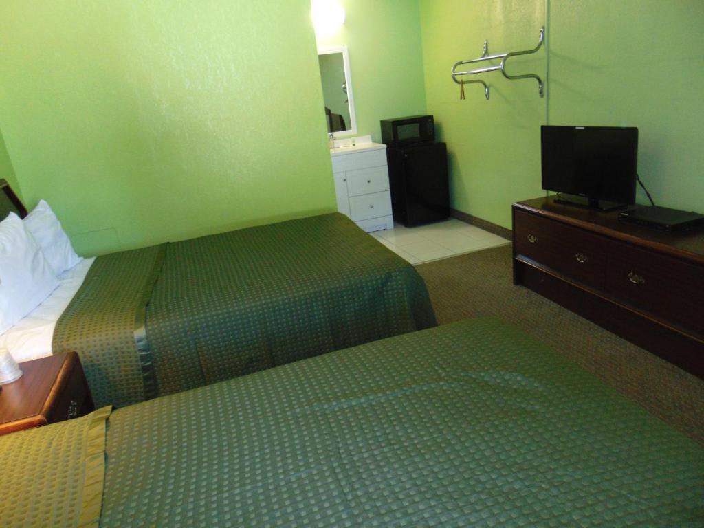 a hotel room with two beds and a flat screen tv at Westbrook Motel in Abbeville