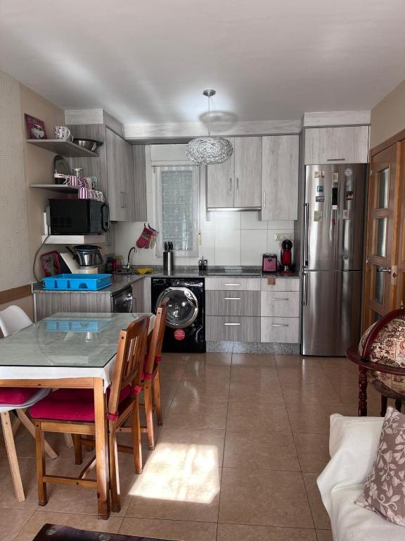 a kitchen with a table and a refrigerator at O Xuncal in San Cosme de Barreiros