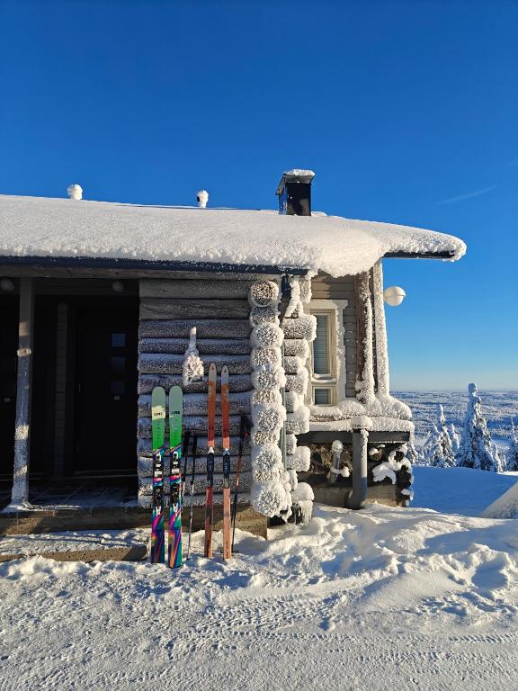 a group of skis in front of a cabin in the snow at Pöllönpesä Iso-Syöte in Syöte