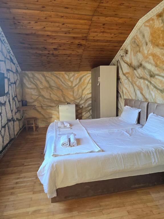 a bedroom with a large bed in a stone wall at Hirmas boutique hotel in Tbilisi City
