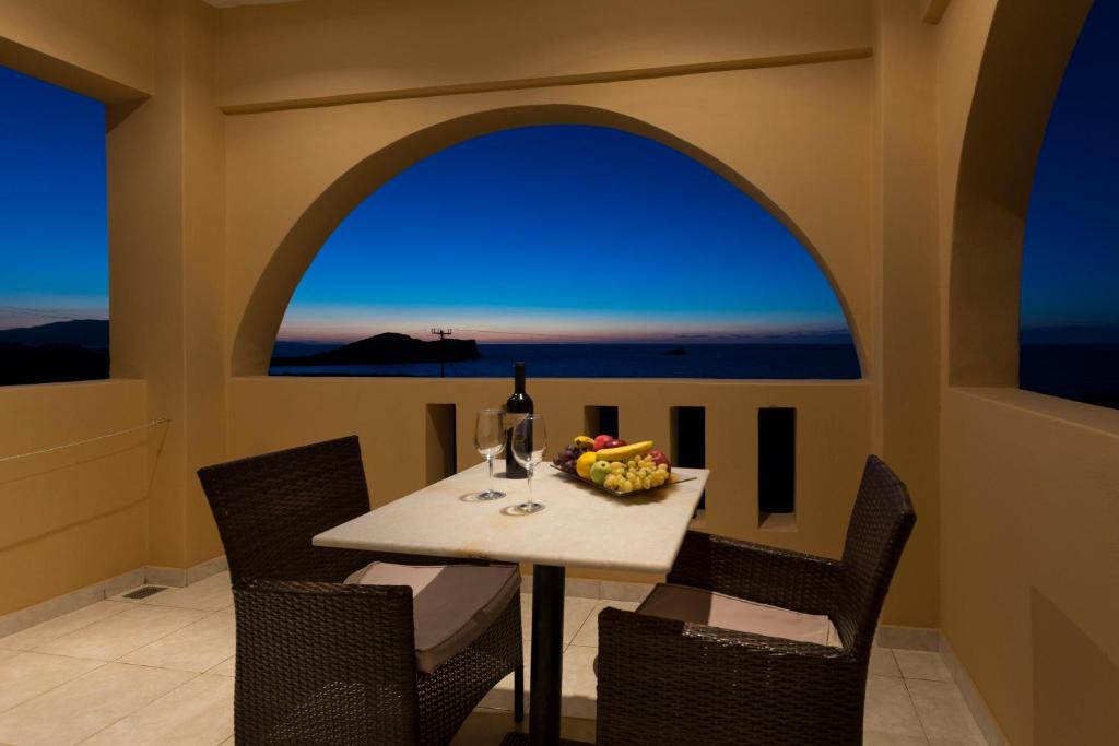 a dining room with a table with a bottle of wine at Archipelagos Apartments in Arkasa
