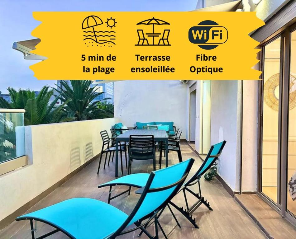 a dining room with blue chairs and a table at Beachside Holiday Apartment in Mohammedia