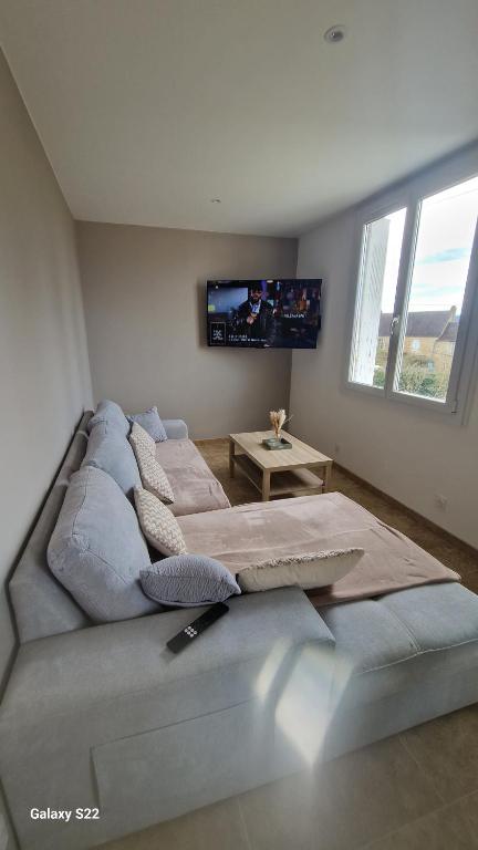 a bedroom with two beds and a flat screen tv at Maison pour 6 personnes in Le Bugue