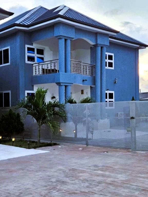 a blue house with a fence in front of it at The Basileia Court in Janman