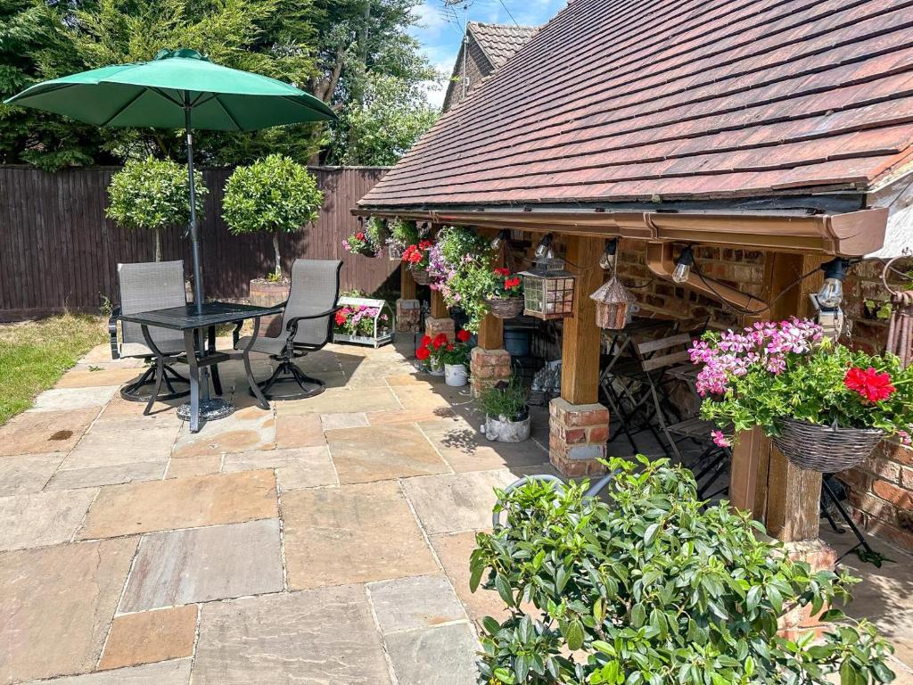 a patio with a table and an umbrella at 1 Bed in Piltdown oc-t36330 in Fletching