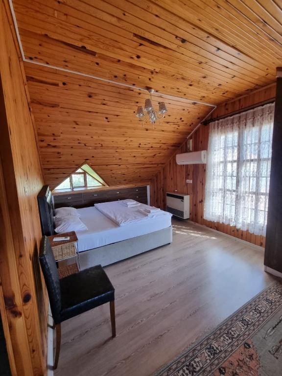 a bedroom with a bed and a chair in a room at Şahmeran Pansiyon in Kemer