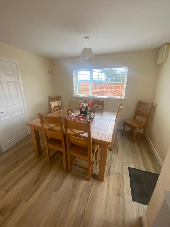 a dining room with a wooden table and chairs at Carrickasticken House in Dungooly Cross Roads