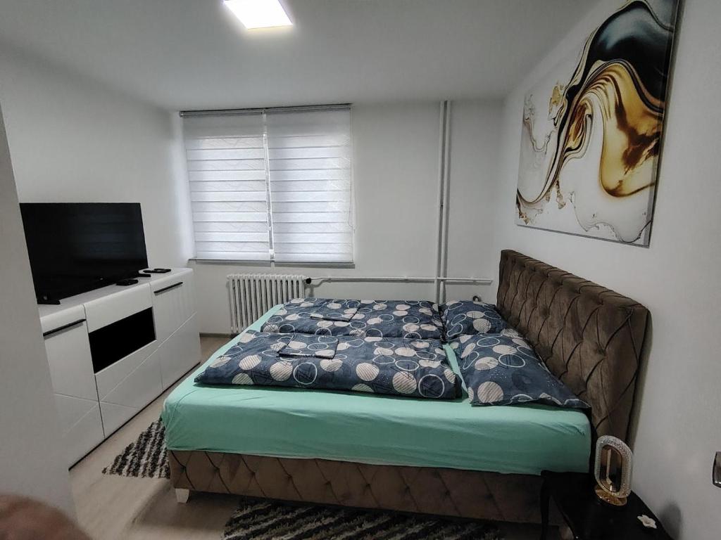 a bedroom with a bed and a flat screen tv at Apartman Pavlica in Kragujevac