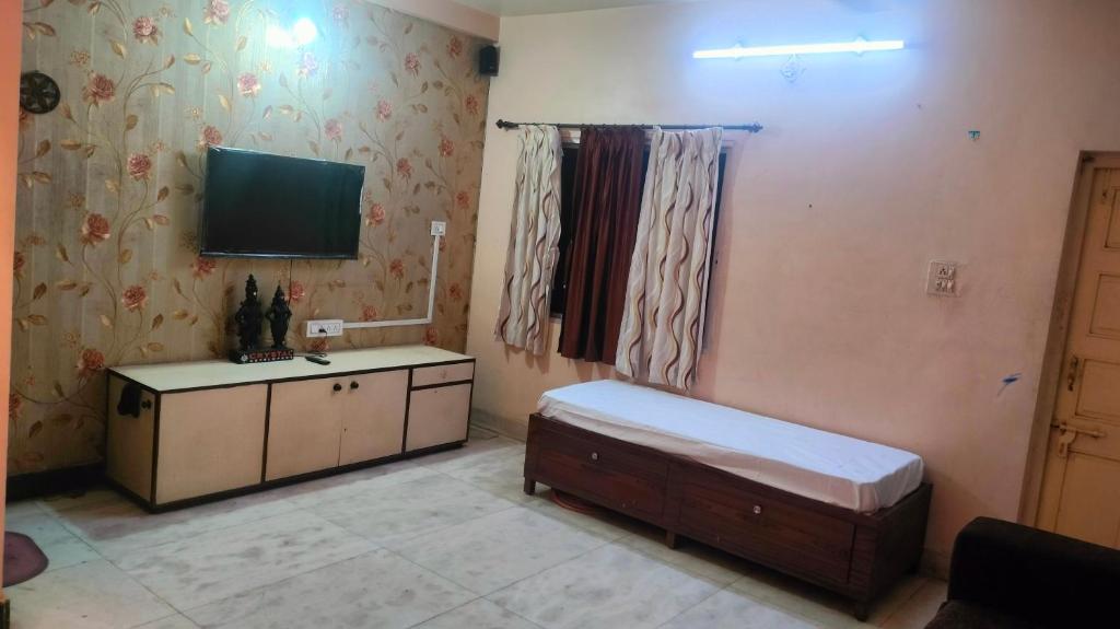 a bedroom with a bed and a tv on the wall at Atithi homestay Solapur in Solapur