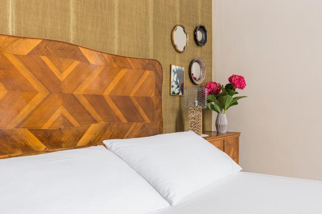ローマにあるDandy Suiteのベッドルーム1室(ベッド2台、木製ヘッドボード付)