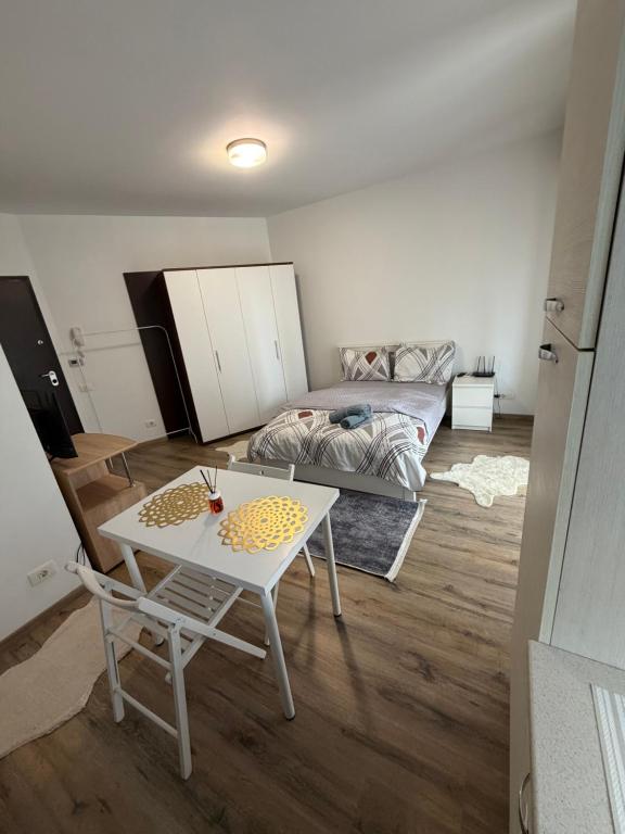 a living room with a table and a bed at Studio Residential Vitan in Bucharest